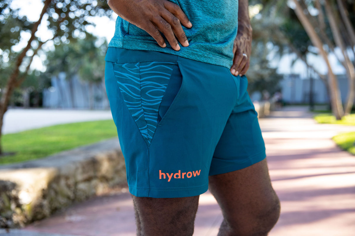 zoomed in photo of man posing in dark blue hydrow wave 3 pocket shorts  