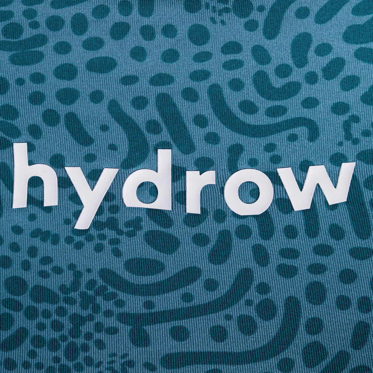 zoomed in hydrow logo on spotted shark pattern leggings