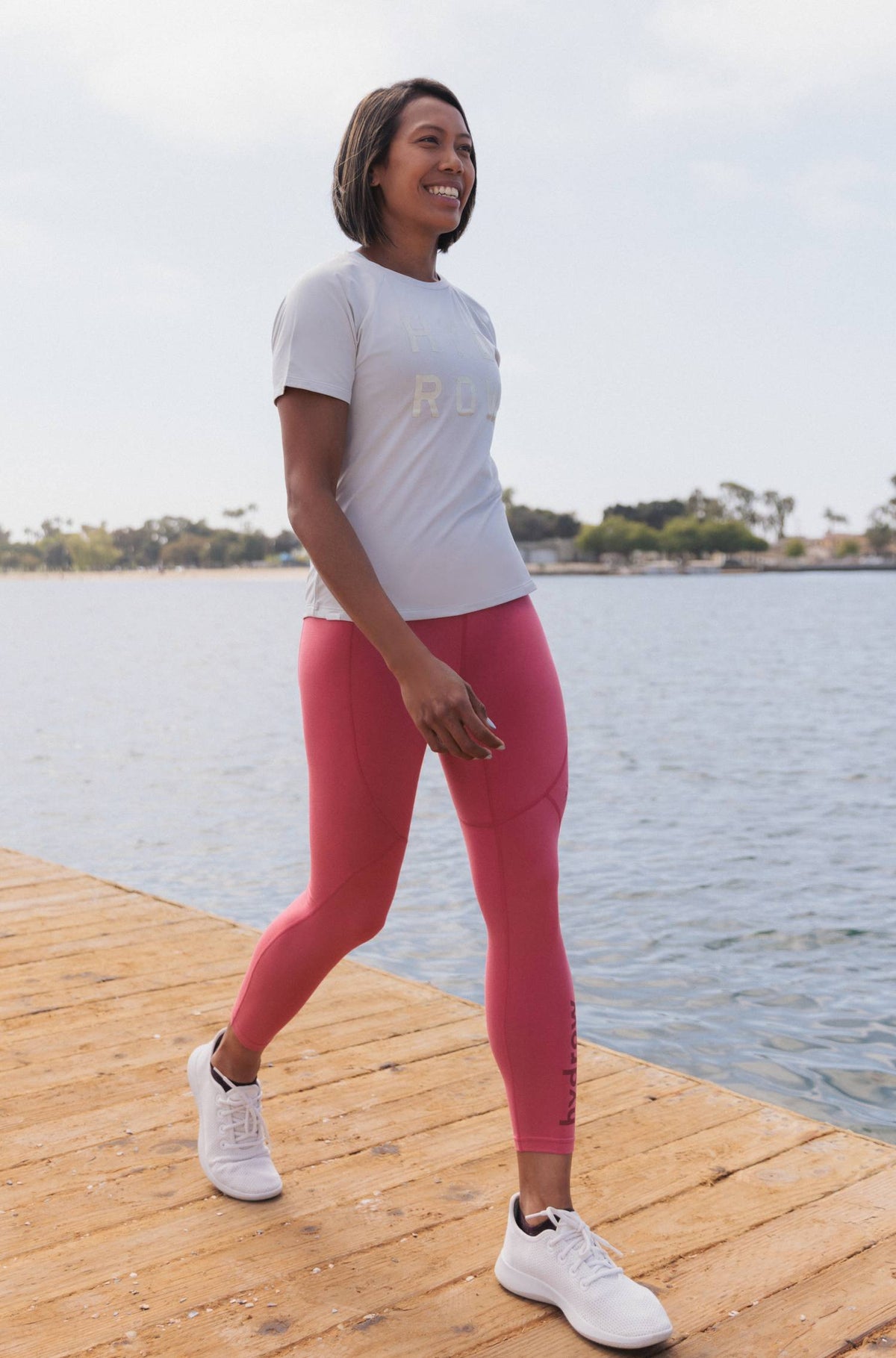 photo of female model wearing rainbow row leggings and tee walking on boat dock