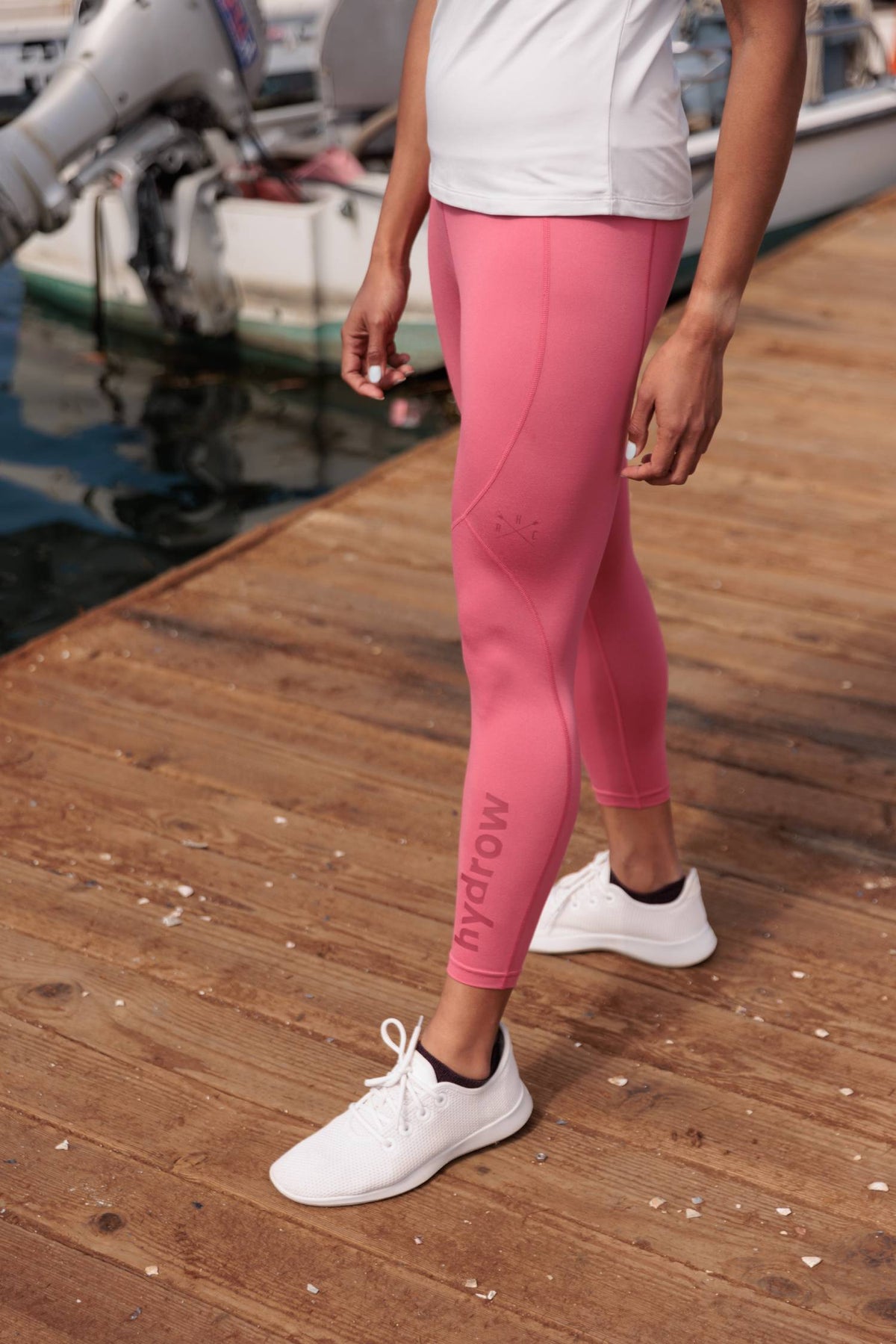 photo of female model wearing rainbow row leggings and tee posing on boat dock