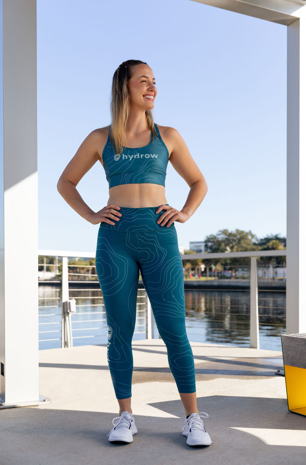 hydrow athlete wearing blue hydrow x Fabletics sports bra and blue hydrow x fabletics leggings
