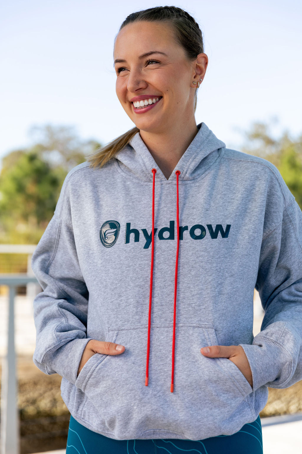 hydrow athlete wearing the forever fleece hoodie with hydrow fabletics logo on center chest