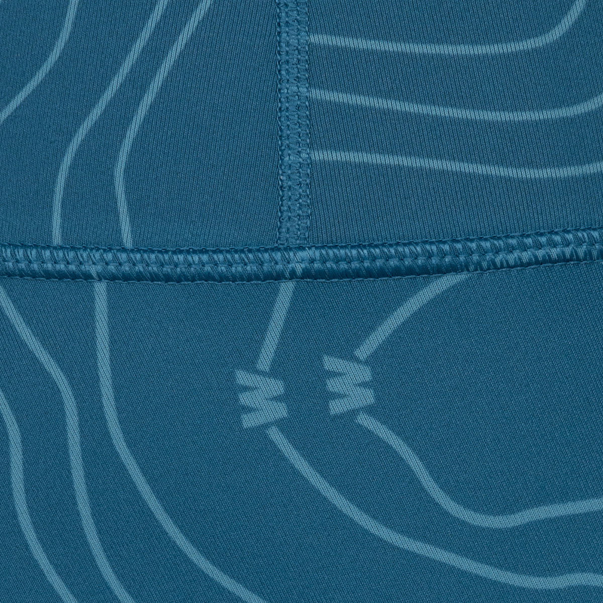 closeup of seams and bathymetic line pattern on Dark blue high waisted 7/8 legging with light blue bathymetic line pattern