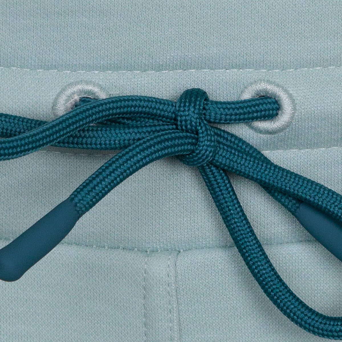 closeup of dark blue drawstring tie waistband on light blue jogger